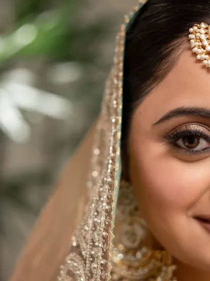 A half-face close-up, showing the precision of the eye makeup. The winged liner and soft shadow create a timeless and beautiful look.