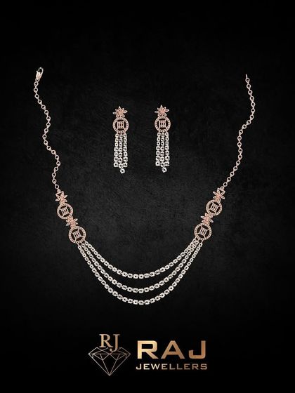 A delicate triple-strand necklace crafted from fine chains and accented with small, sparkling motifs. This piece offers a layered look in one, perfect for adding a touch of sophisticated sparkle.