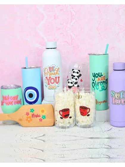 A collection of our personalized drinkware, including "Self Love" and "Be Proud" bottles, a panda-themed glass, an evil eye tumbler, and custom coffee glasses.