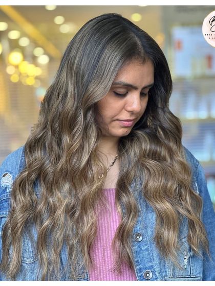 The soft waves and neutral brown tones create a look of effortless, timeless allure.