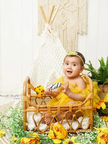 A sunny, boho-inspired sitter session. This baby girl is surrounded by sunflowers and natural textures, creating a bright and cheerful atmosphere.