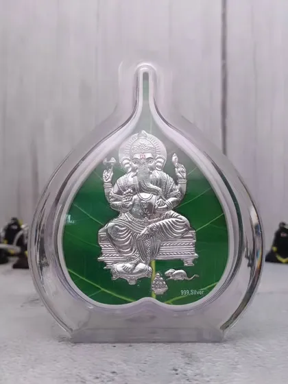 Yeh 999 pure silver Ganesha ka chitra hai, jise ek paan ke patte ke aakar ke frame mein banaya gaya hai. Yeh Ganesh Chaturthi par gift dene ke liye ekdum sahi hai.