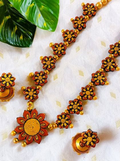 The same floral necklace design in a warm, rustic brown and yellow. This color combination has a very earthy and traditional feel.