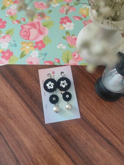 These tiered fabric earrings with pearl drops are a modern and chic design. They are available in pink, black, and teal, and are incredibly lightweight and comfortable.