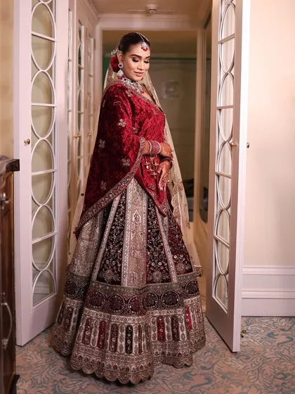 The bride posing elegantly, showcasing her complete look. The red and silver jewellery set is a modern take on traditional bridal wear.