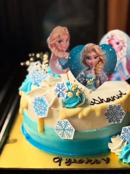 Another look at the detailed Frozen princess cake, showing the placement of the snowflake decorations and the drip effect.