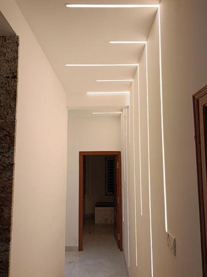 A hallway featuring striking profile lighting that runs from the wall to the ceiling. This design element not only illuminates the space but also adds a dramatic, architectural feature.