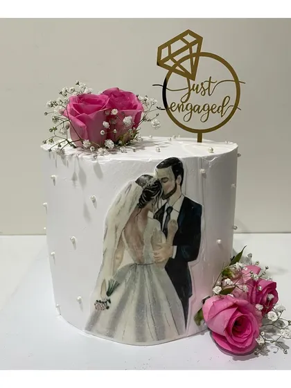 A 2kg tall engagement cake with a custom photo print. The cake is decorated with fresh pink roses and baby's breath for a personal and romantic touch.