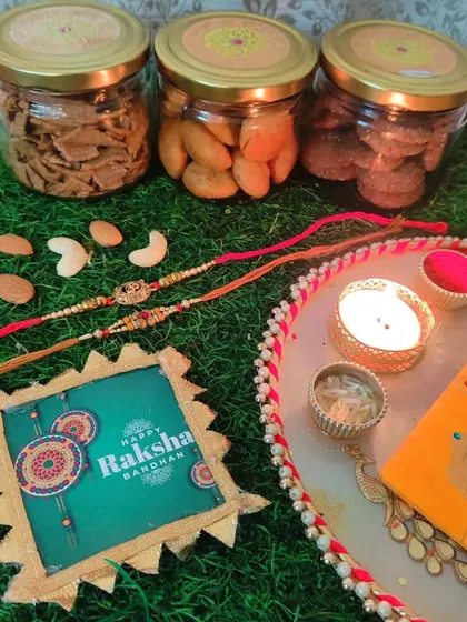 A complete Rakhi celebration setup. Our hamper with healthy snacks is paired with a traditional pooja thali, making it a complete gift for your sibling.