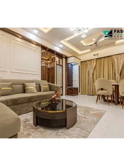 A comfortable and chic living room in Bhiwandi. The neutral-toned sofa and circular coffee table are set against a backdrop of wood-paneled walls and classic molding, creating a balanced and timeless look.