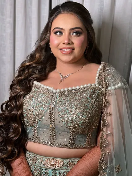 A close-up of the bride's happy expression. The hairstyle is swept to the side, highlighting her jawline and necklace.