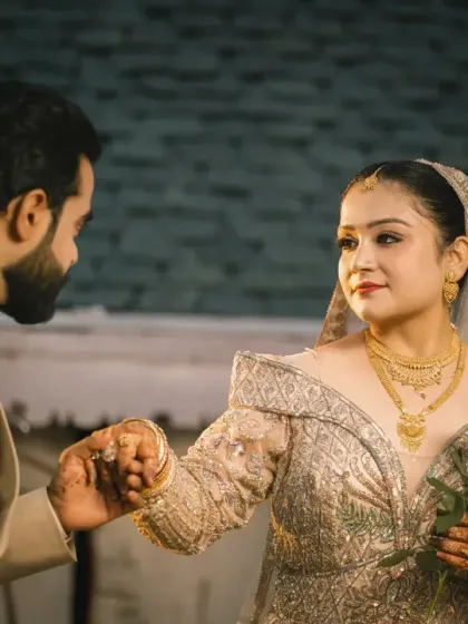 A gentle, romantic moment as the groom holds his bride's hand. The soft lighting and their expressions make this a timeless and classic wedding portrait.