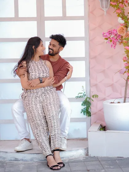 A tender moment against a romantic floral backdrop. The soft pink tones and the couple's gentle embrace create a dreamy and affectionate pre-wedding portrait.