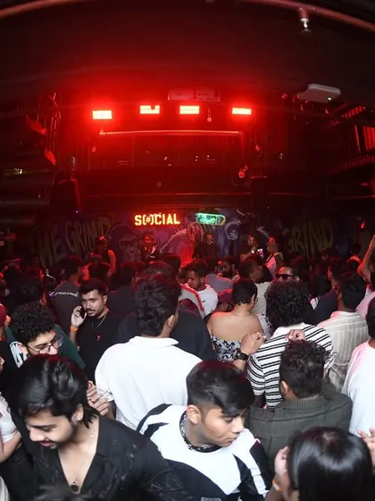 A full view of the club under the red lights, showing the scale of the party.