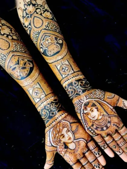 A unique design with portraits of the bride and groom on the palms, and symbolic elements like a diya and kalash on the arms.