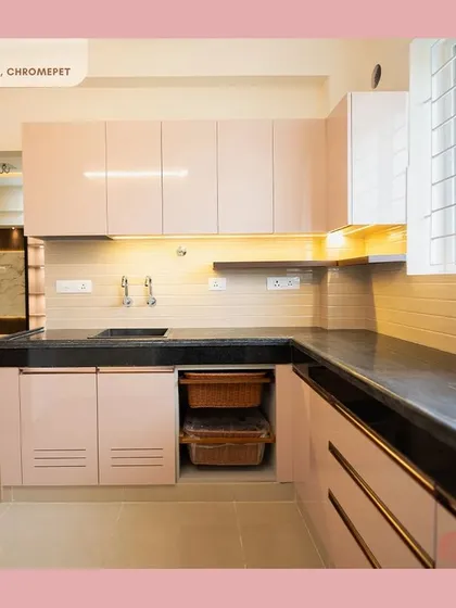 This elegant L-shaped kitchen in a soft pastel pink demonstrates our ability to create beautiful and functional spaces. The design incorporates an efficient vegetable basket pull-out and under-cabinet lighting, proving that practical kitchens can also be incredibly stylish.