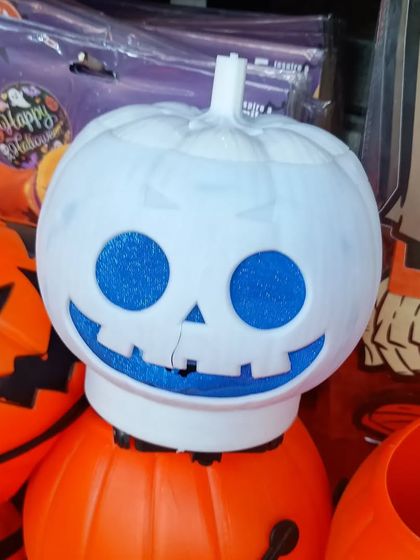 A unique white pumpkin decoration with blue glittery eyes and a smile. This offers a different color palette for your Halloween setup.