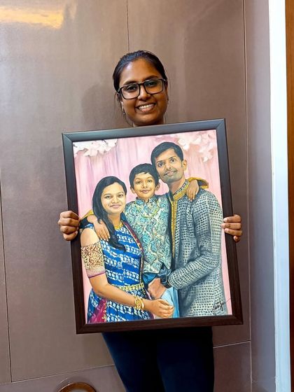 Me holding the framed family portrait, ready to be shipped to Hyderabad.