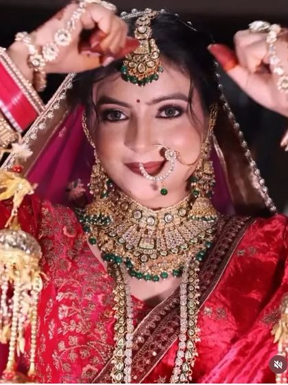 A close-up of a bride adjusting her jewellery, giving a clear view of the intricate design of the Kundan choker, nath, and kalire attached to her bangles.