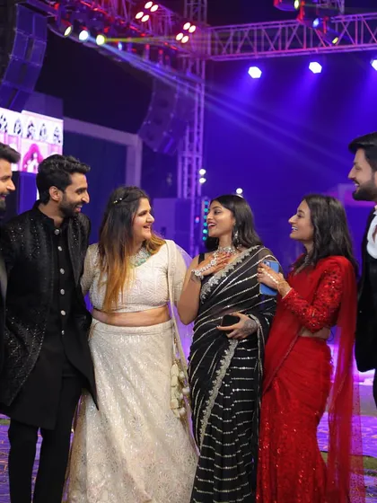 A candid shot of friends chatting at the wedding reception. My black saree stands out next to the white lehenga and red saree, showing the diversity of wedding fashion.