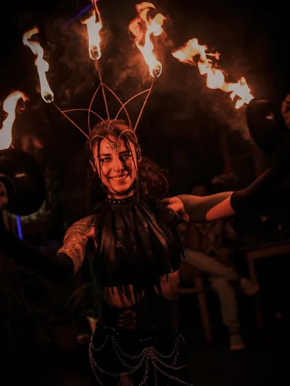 A smile from behind the flames. Beyond the performance, we are artists and craftspeople. We design and build custom fire props like this crown and offer lessons for those who want to start their own journey with fire.