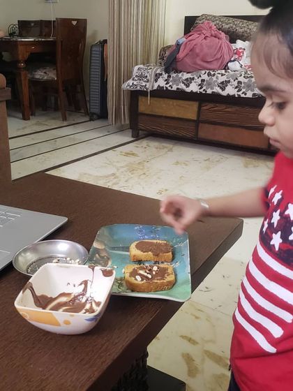 A close-up of the student engaged in her chocolate rusk project. These activities are designed to be both educational and enjoyable.
