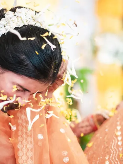 The bride ducks as she's showered with flower petals, a candid and action-filled shot.