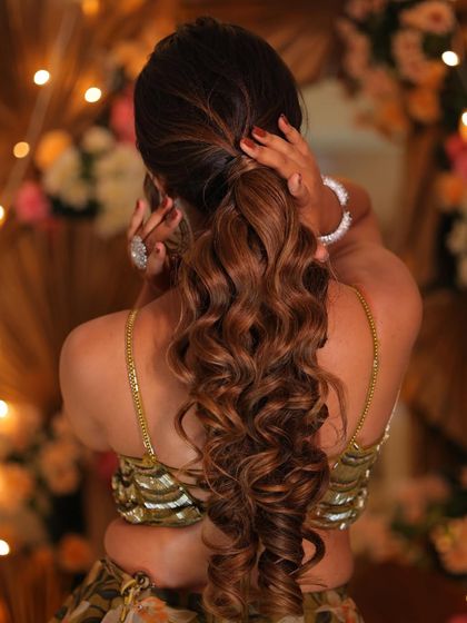 A view of the fresh and peppy beach waves ponytail. This hairstyle is perfect for a reception, keeping the hair stylishly away from the face.
