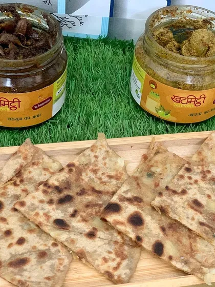 A beautiful shot from a food blogger featuring my Lahsun and Amla pickles served with hot parathas. This is the perfect way to enjoy them.