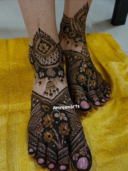 A close-up of the feet from a full bridal set, featuring beautiful hanging jhumka (earring) motifs and floral details.