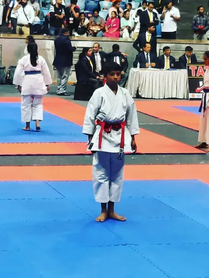 A young competitor stands ready on the tatami mat, focused and prepared for his kata performance at the Independence Cup.