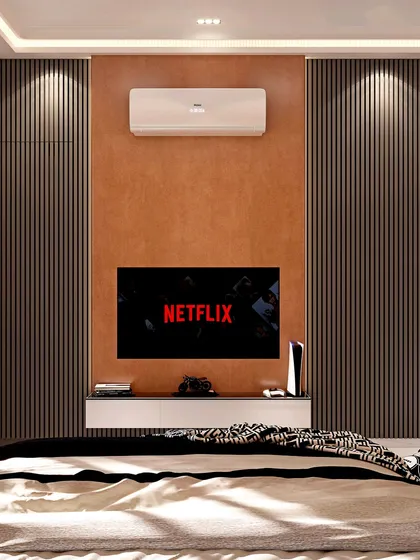 This bedroom design focuses on a sophisticated entertainment experience. The television is mounted on a textured tan accent wall, framed by dark, vertically fluted panels that conceal wardrobe space, creating a clean and integrated look.