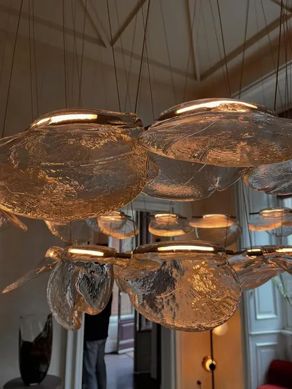 A close-up of a large, horizontal installation of the Bocci 141 series, showing how the individual pendants are clustered to create a substantial chandelier.