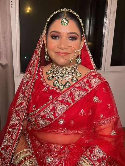 A full view of the bride in her stunning red and green ensemble. The makeup is bold enough to stand out yet elegant enough to feel timeless.
