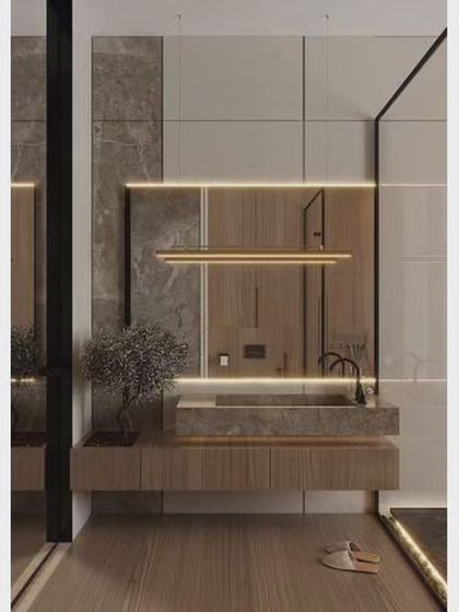 A high-end bathroom design using marble-look tiles and integrated lighting. The floating vanity and minimalist fixtures contribute to the sleek, luxurious feel.