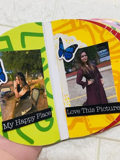 An inside page of the semi-circle album, decorated with colorful patterns and butterfly stickers to frame the photos.