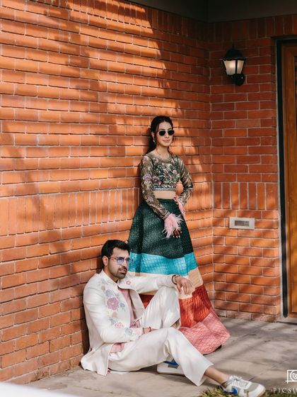 A stylish, editorial-style shot of the couple against a brick wall.