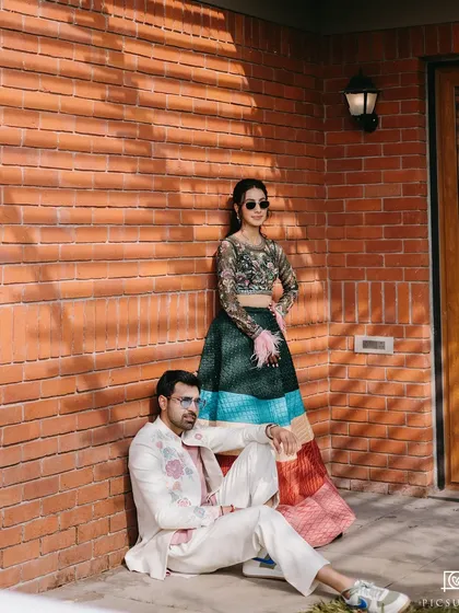 A stylish, editorial-style shot of the couple against a brick wall.