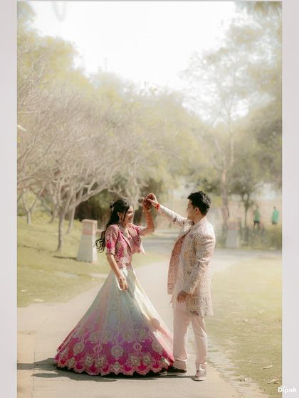 A dreamy, light-filled photo of a couple dancing during their Mehendi celebration. The soft focus and bright background create a magical, ethereal quality.