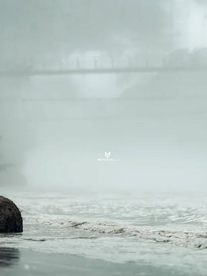 A dramatic pose on the riverbank, with the couple looking out at the misty landscape. This shot has a very atmospheric and cinematic feel.
