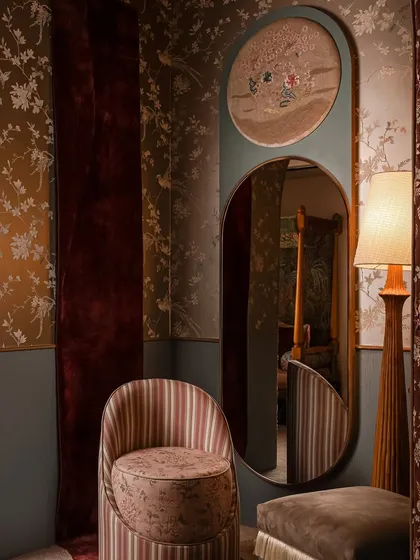 Welcome to Zone Two, a space inspired by the softness and intricacy of a boudoir. Here, a custom mirror with an embroidered panel sits beside a striped chair and a unique wall rug that appears to spill onto the floor, creating a sense of movement.