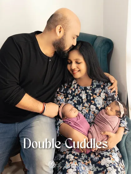 Double cuddles. A relaxed and loving family portrait in our studio's comfortable armchair, filled with the warmth of a new family of four.