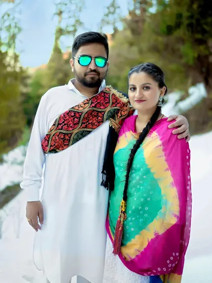 A vibrant pre-wedding shoot in the snow, with the couple in colorful traditional attire. The contrast between the bright clothes and the white snow makes for a visually stunning and culturally rich portrait.