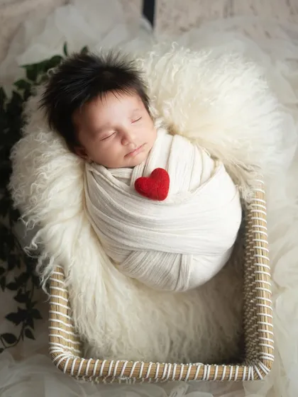 A slightly different angle of our little heartthrob, showing the beautiful texture of the swaddle and the peaceful expression on the baby's face.