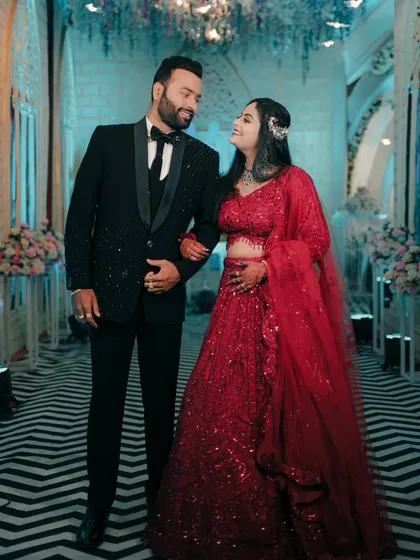 A happy reception portrait. The couple walks arm in arm through a beautifully decorated corridor, smiling at each other.