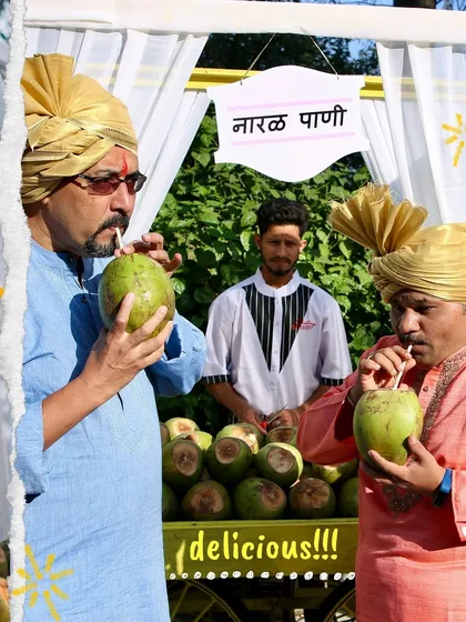 Guests in traditional Maharashtrian attire enjoy sipping on fresh coconut water from my 'Nariyal Pani' cart. It's a perfect, healthy way to stay hydrated during wedding festivities.