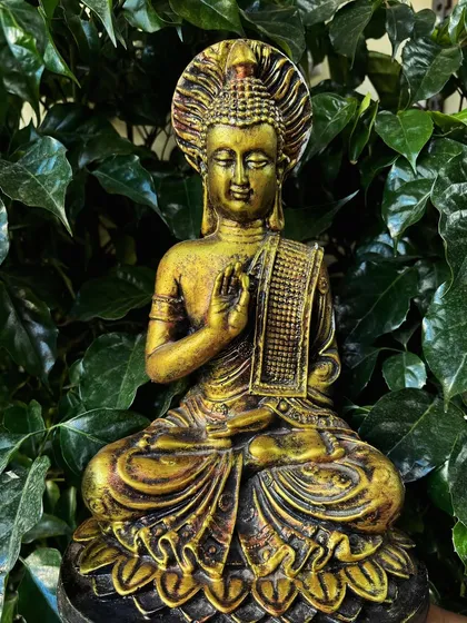 Here, the golden Buddha statue is placed against a backdrop of lush green ivy. This simple pairing creates a powerful image of tranquility and nature's beauty.