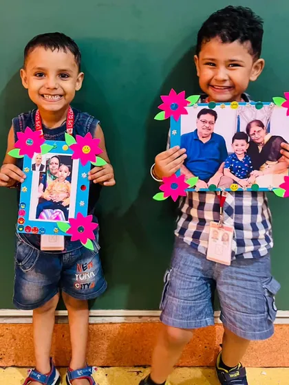 Two boys proudly hold up the photo frames they crafted for their grandparents, a beautiful keepsake to celebrate their timeless bond.