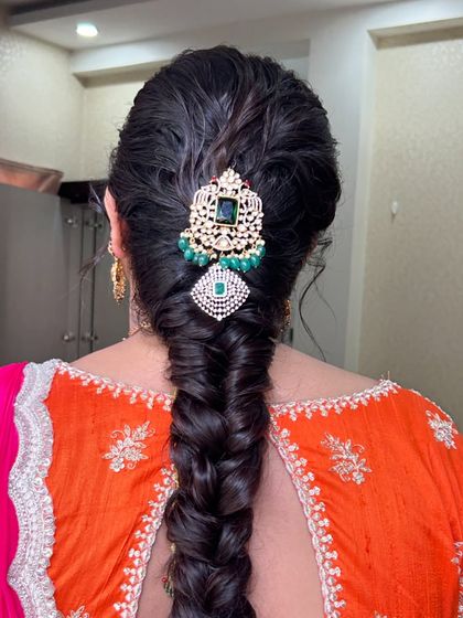 A close up on the stunning hair jewellery adorning this classic fishtail braid, perfect for a bride.