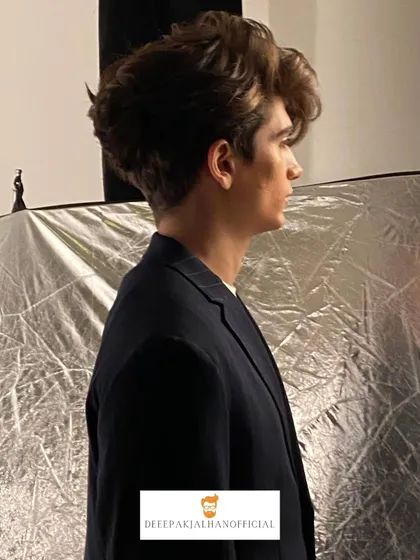 Men's grooming is about creating sharp, versatile styles. This look, captured behind the scenes at a shoot, showcases a modern cut with volume and texture that's both stylish and effortless.
